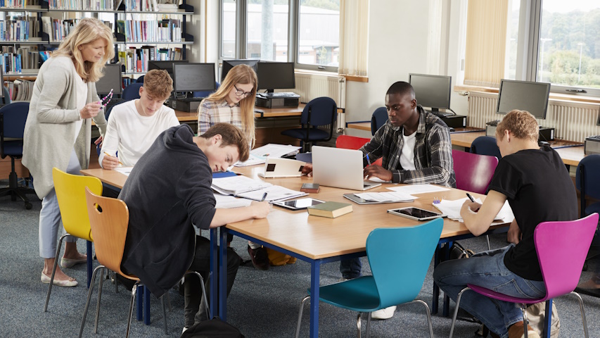 Foto di archivio, un gruppo di ragazzi e ragazze studiano in biblioteca