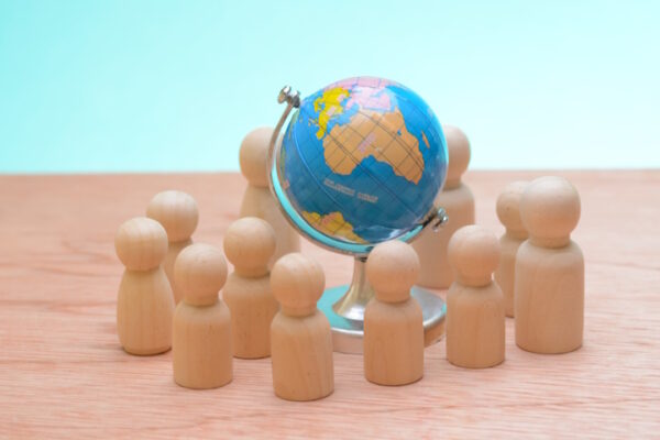 immagine concettuale, figurine di legno circondano il globo terrestre